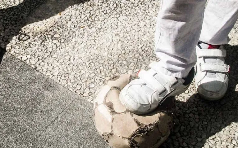 Child playing with an old ball. Photo: Save the Children