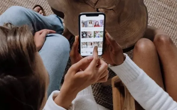Two people showing each other photographs with their mobile phones.