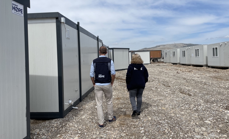 Türkiye country director Adam Jacovou and program coordinator Nezahat Yildirim look at shelter containers to house health care workers in Adiyaman.