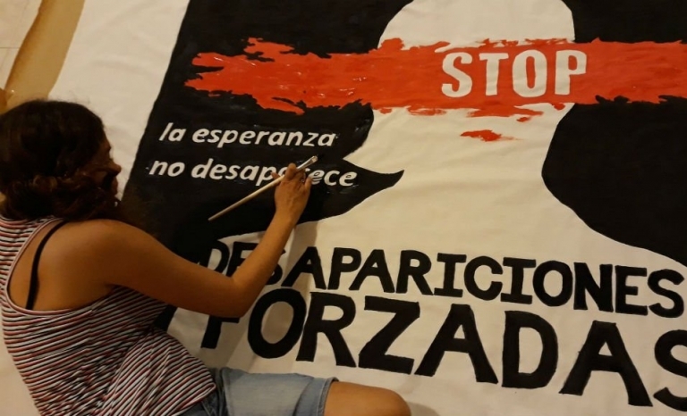 Image of someone from Taula per Mèxic making a poster